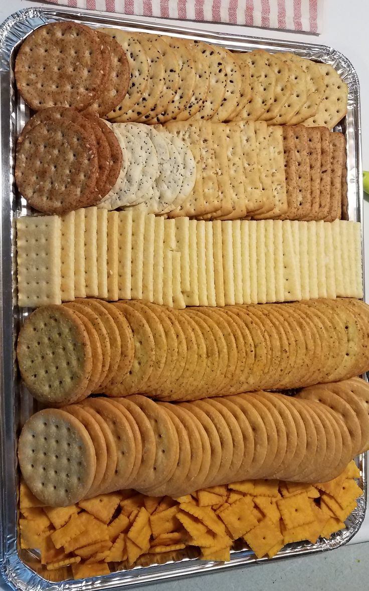 an assortment of crackers and cheeses in a tray