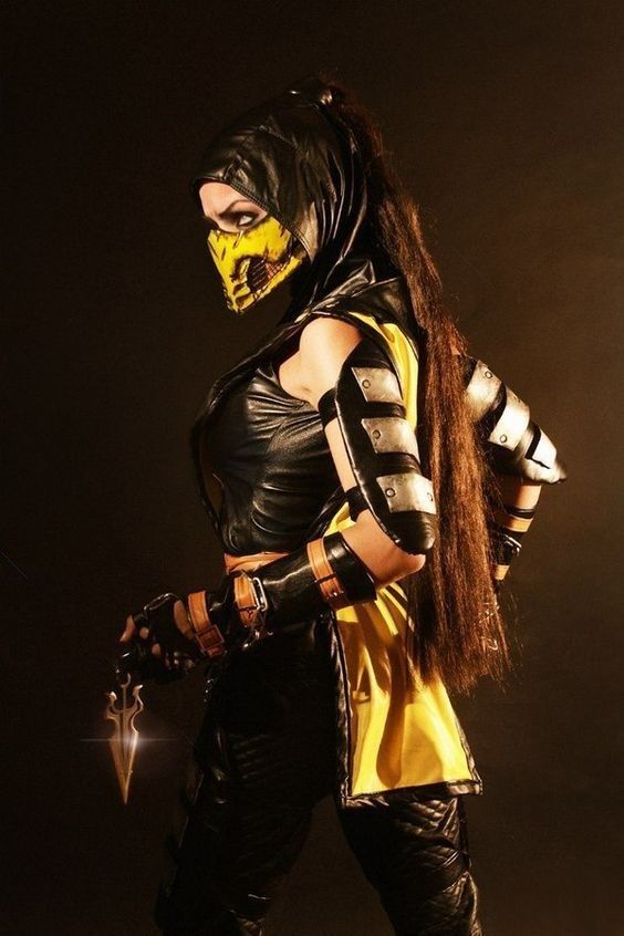 a woman in a yellow and black outfit with long hair, wearing a mask and gloves