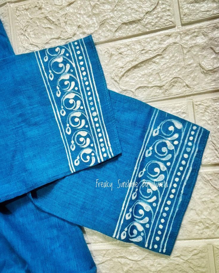 three blue napkins with white designs on them