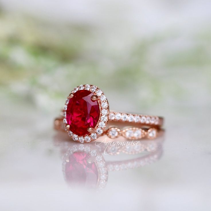 Beautiful Vintage Inspired Ruby Ring ►Base Metal: Sterling Silver (S925) ►Plating: 14K Rose Gold Vermeil ►Accented With Simulated Diamonds ►Can be paired with one or two half-eternity Milgrain bands of your choice Center Stone: Ruby Grade: AAA Stone Cut: Oval Gem size: 8.0 x 6.0 mm Carat Weight: 1.21 ct. Gemstone creation: 100% Genuine Lab-Grown Ruby Stone Origin: Russia ►Please be aware that plated jewelry can wear off over time, if this is a concern we would suggest going with the sterling sil Classic 14k Rose Gold Rings With Accent Stones, Classic Ruby Halo Ring, Classic Rose Gold Rings With Accent Stones, Vintage Ruby Ring With Halo Setting For Wedding, Classic Ruby Ring With Halo Setting For Promise, Classic Halo Ruby Promise Ring, 14k Rose Gold Halo Promise Ring, Rose Gold Ruby Wedding Ring With Prong Setting, Heirloom 14k Rose Gold Promise Ring