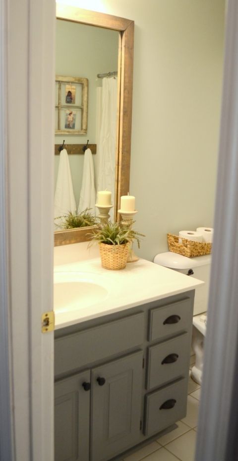 a bathroom with a sink, mirror and toilet paper roll on the counter in front of it