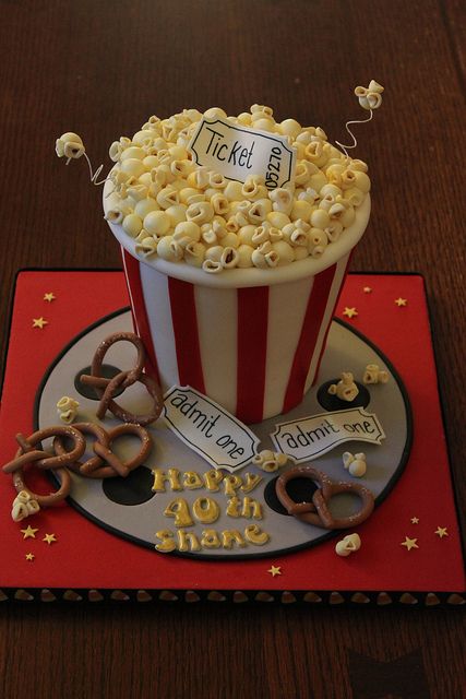 a birthday cake made to look like a bucket of popcorn and some pretzels