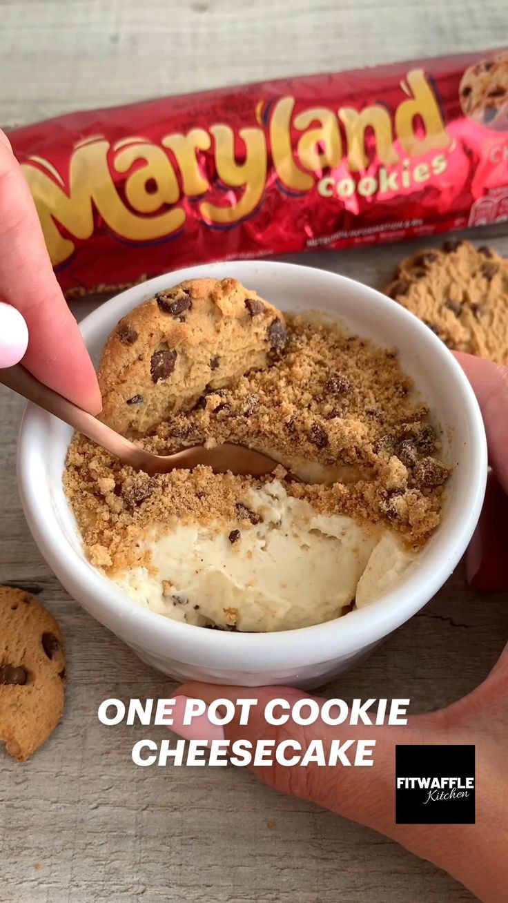 a person is dipping some ice cream into a bowl with chocolate chip cookies on the side