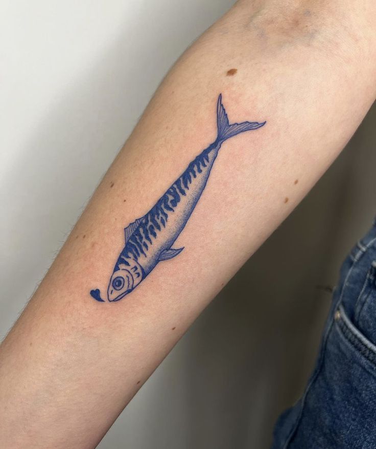 a blue fish tattoo on the arm