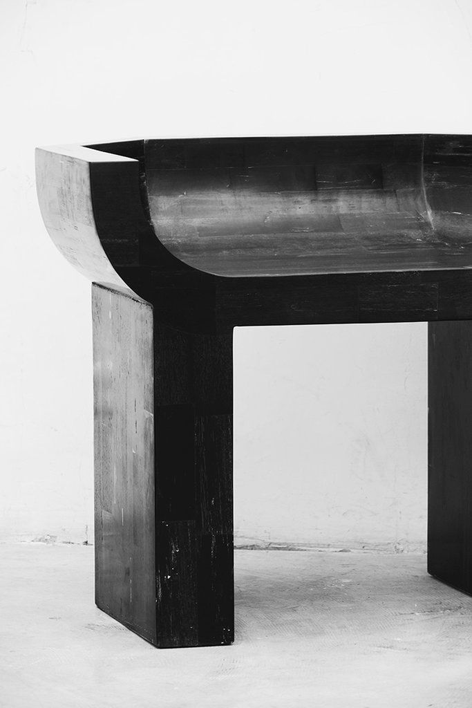 a black and white photo of a bench made out of wood with a curved top