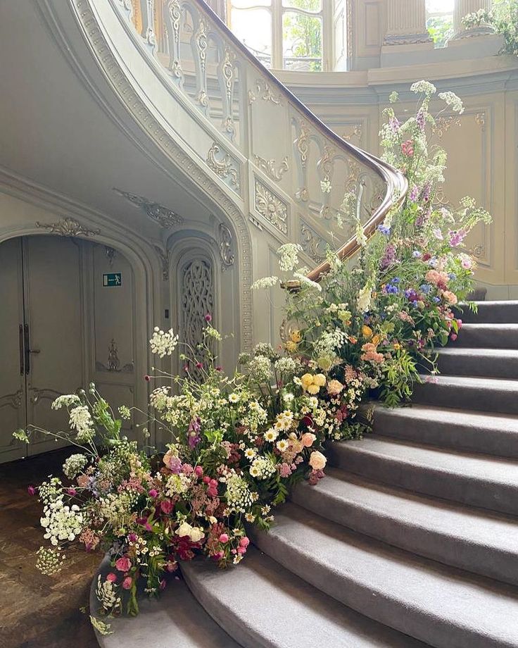 a bunch of flowers that are sitting on the stairs in front of a set of stairs