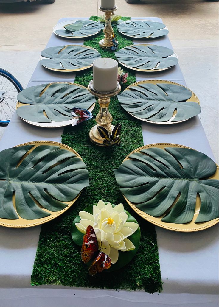 a long table with plates and flowers on it