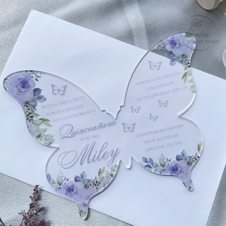 a butterfly shaped wedding card with purple flowers on it