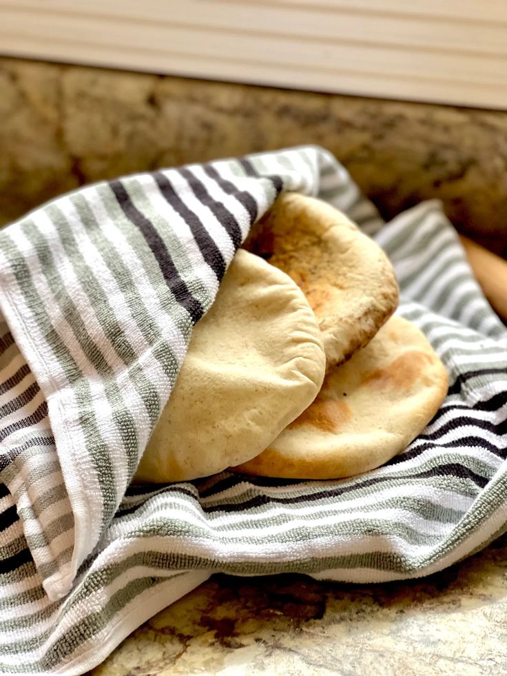 two pita breads sitting on top of a towel