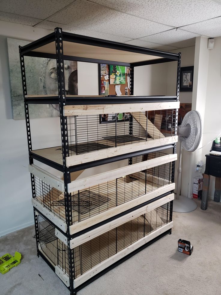 a large caged animal house in the middle of a room with other items on the floor