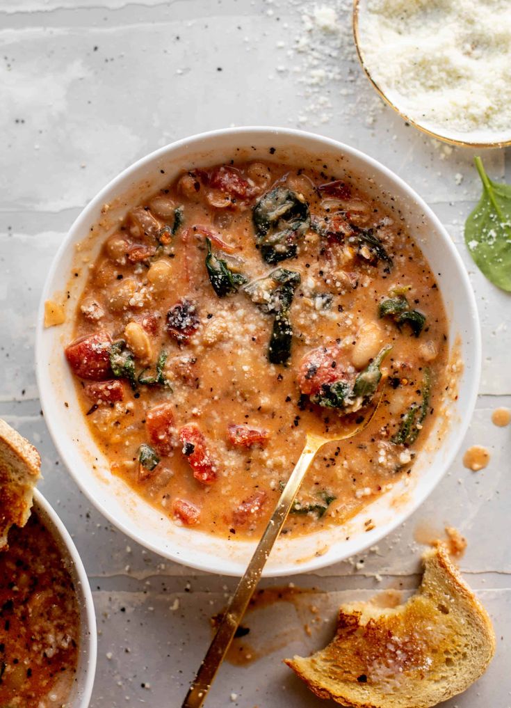 a white bowl filled with soup next to bread