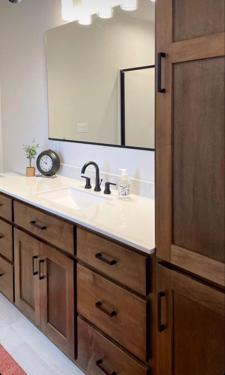 a bathroom with wooden cabinets and white counter tops