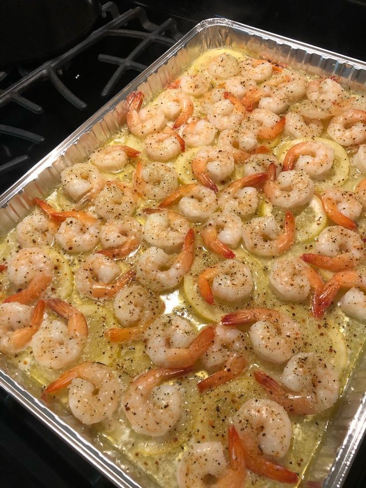 a pan filled with shrimp and vegetables on top of a stove