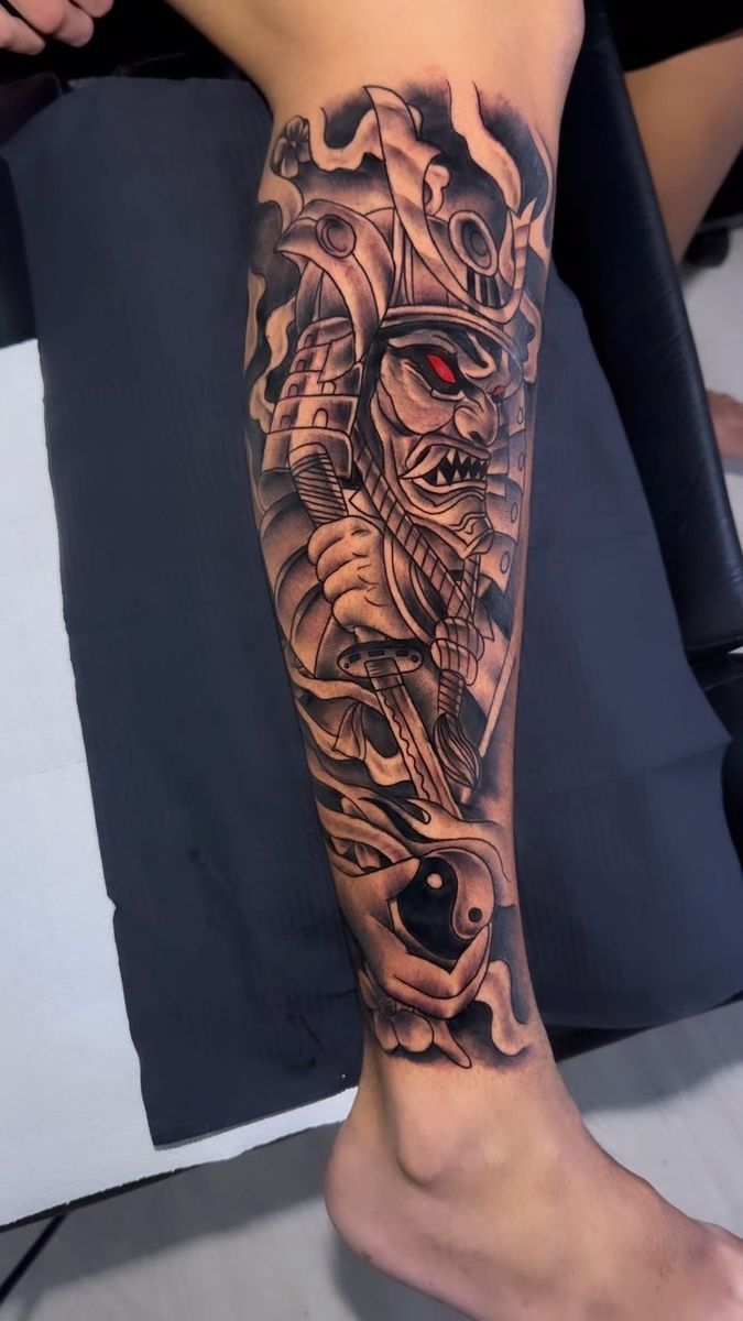 a man's leg with a tattoo on it and a skull in the middle