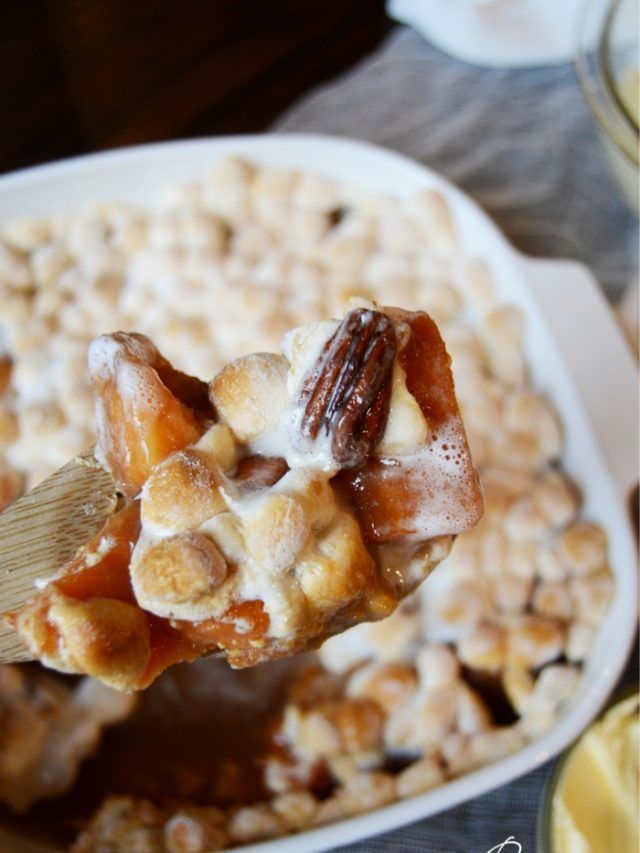 a spoon full of sweet potato casserole with nuts