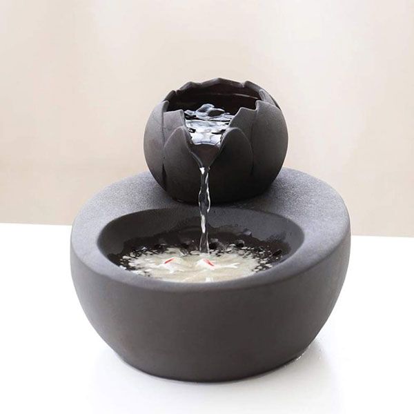 a black bowl with water coming out of it