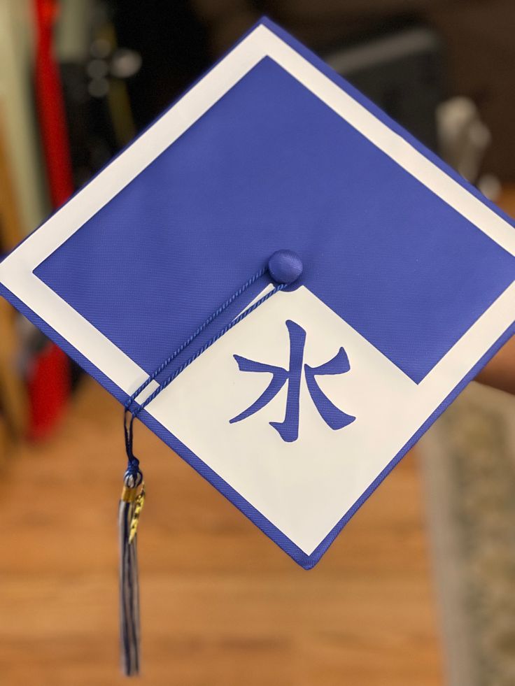 a blue and white graduation cap with chinese characters on it's side hanging from the ceiling