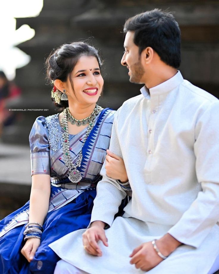 a man and woman sitting next to each other on a bench smiling at each other