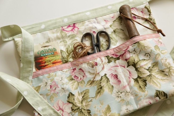 an old pair of scissors and some other items in a floral fabric bag on a table