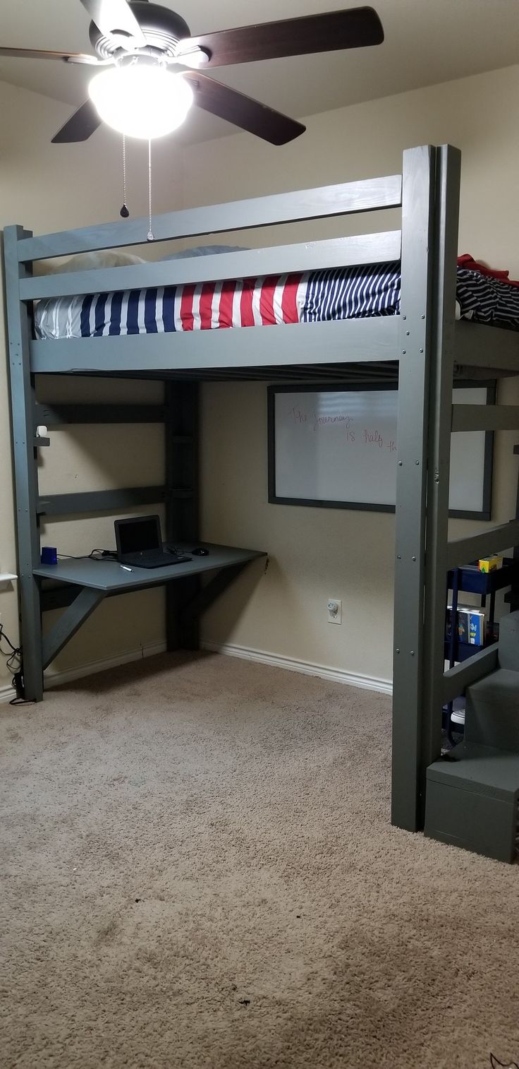 there is a loft bed with a desk underneath it and a ceiling fan in the corner