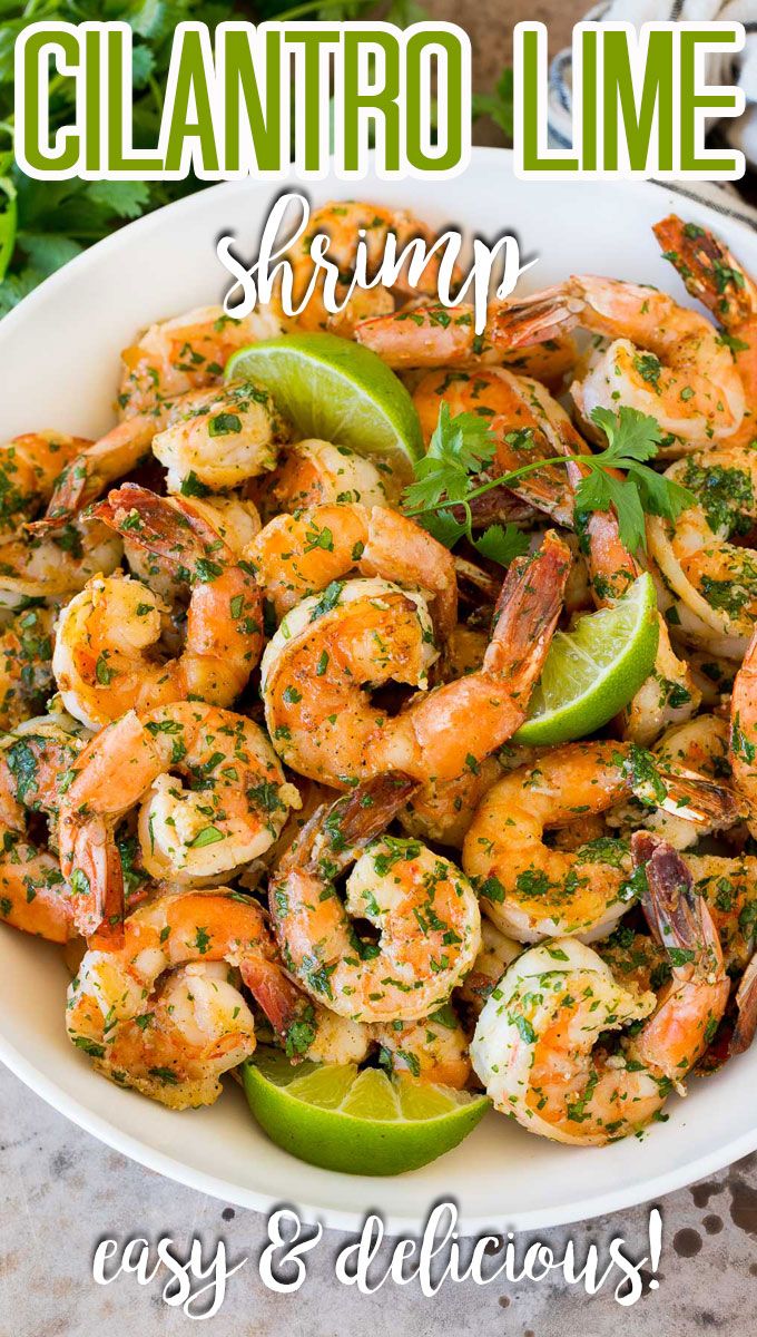 a white bowl filled with shrimp, limes and cilantro lime slurry