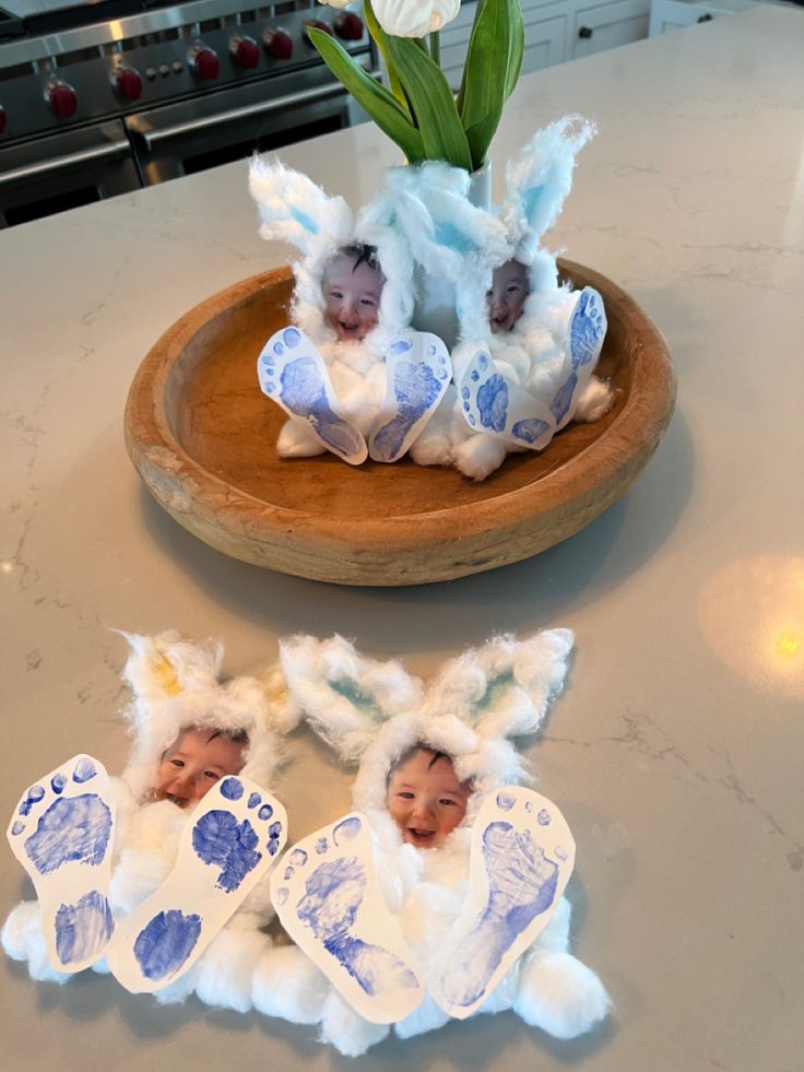 two baby feet are placed next to some fake babies in blue and white outfits on a table