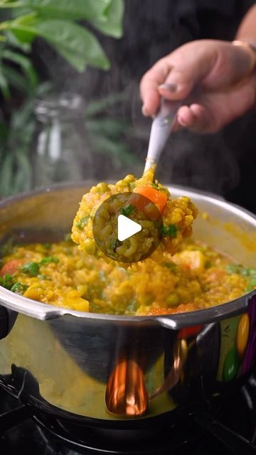 a person stirring food in a pot on the stove