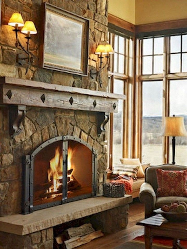 a living room filled with furniture and a fire place in the middle of a stone fireplace