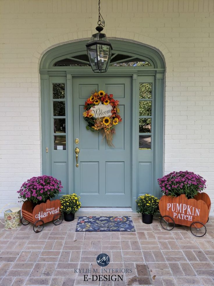 a blue front door with pumpkins and sunflowers