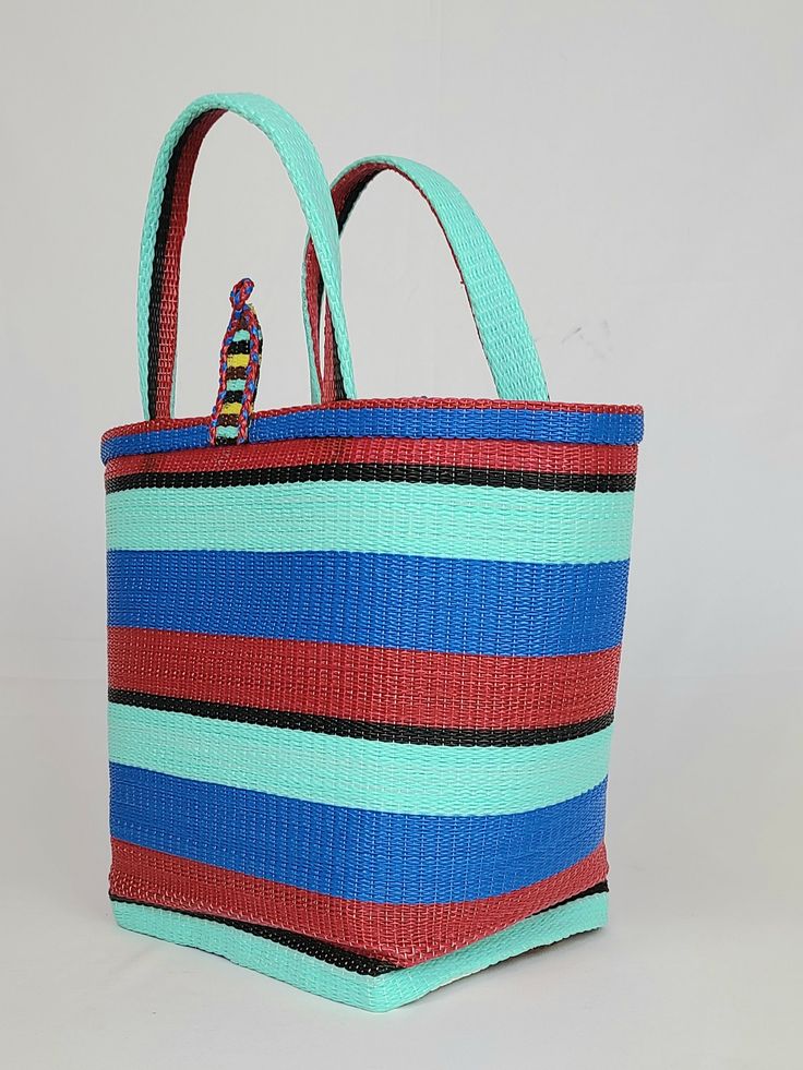 Material: Recycled plastic. Color: Red, blue, sky blue, black. Size: Height 12" Width 14" Use: Grocery, beach, pool... Property: Waterproof, easy to clean. Origin: West Africa. Handwoven bags made from recycled plastics. This bag is waterproof and very easy to clean. This material is very strong and can hold heavy contain. Blue Plastic Tote Bag, Blue Recyclable Beach Bag For Summer, Multicolor Recyclable Beach Bag For Vacation, Eco-friendly Blue Beach Bag For Beach Season, Blue Everyday Bag Made Of Recycled Materials, Eco-friendly Blue Tote Beach Bag, Eco-friendly Blue Beach Bag For Vacation, Large Blue Beach Bag For Travel, Eco-friendly Summer Bag From Recycled Plastic Bottles