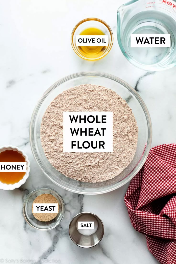 ingredients for whole wheat flour in bowls on a marble counter top with the words whole wheat flour above them