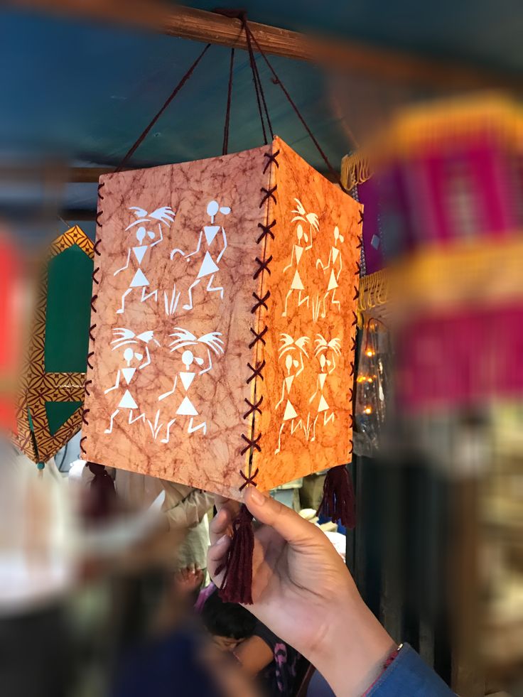 a person is holding up a paper lantern