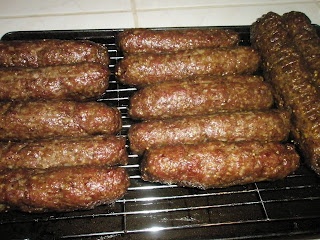 several sausages are cooking on a grill