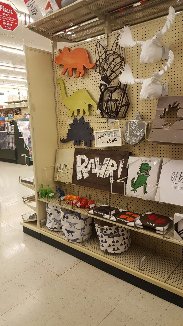 there are many items on the shelf in this store that is decorated with dinosaurs