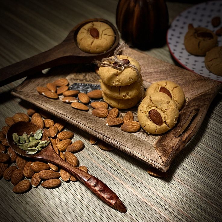 almonds and cookies are arranged on a wooden tray