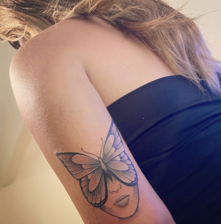 a woman with a butterfly tattoo on her arm