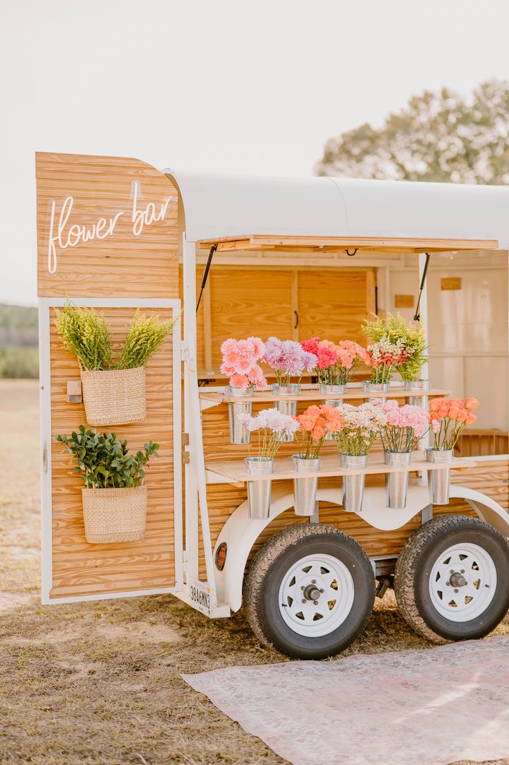 an old trailer converted into a flower bar