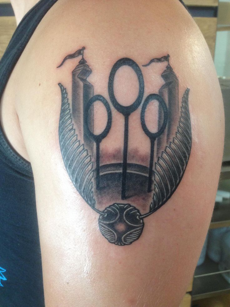 a tattoo on the back of a man's shoulder with scissors and an egyptian symbol