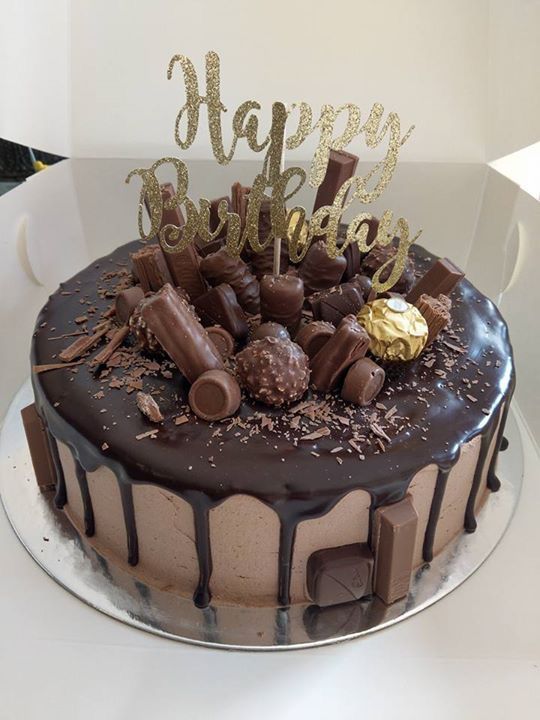 a birthday cake with chocolate frosting and decorations