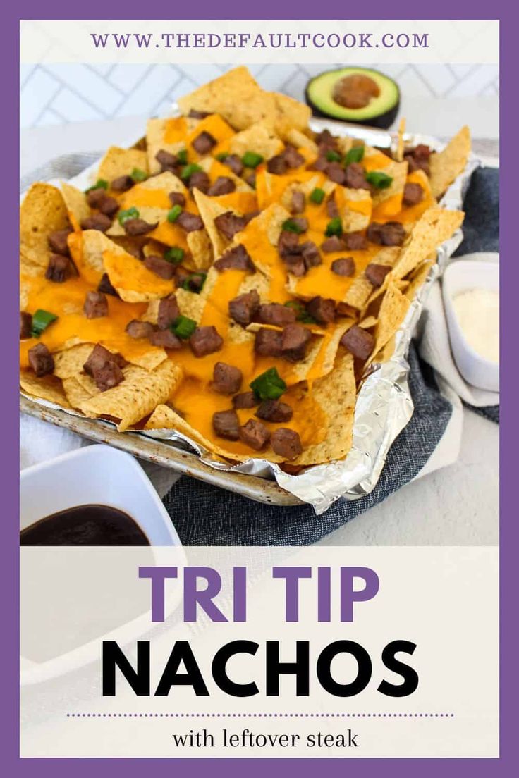 a tray filled with nachos covered in cheese and meat next to an avocado