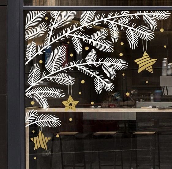 the window is decorated with white and gold decorations, including pine cones and bells on them