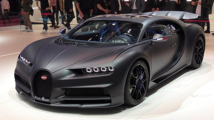 a bugatti type car on display at an auto show with people standing around