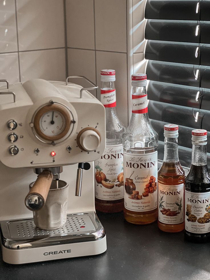 an espresso machine sitting on top of a counter next to bottles of alcohol