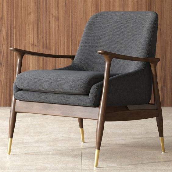 a gray chair sitting on top of a floor next to a wooden wall