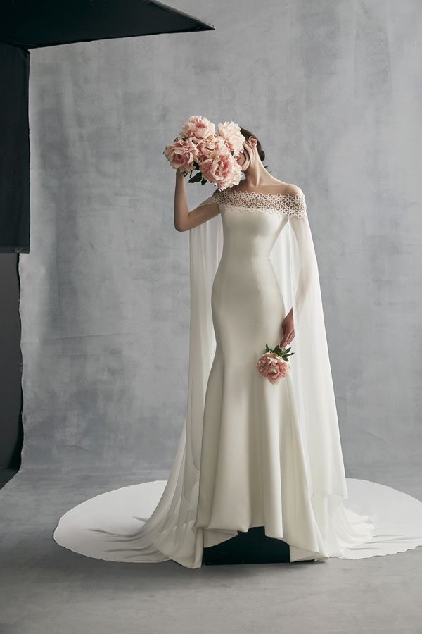 a woman in a wedding dress with flowers on her head and veil over her face