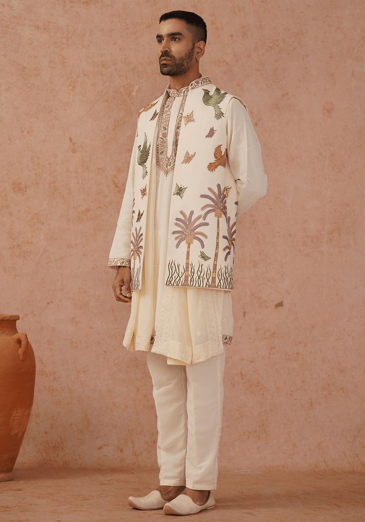 Step into sophistication with Off White Jacket Kurta Set. Crafted from luxurious georgette, the jacket showcases exquisite resham and sequinned embroidery work, while the yoke design kurta features stunning all-over motifs and meticulous detailing. Completed with a beautifully embroidered dupatta and matching pants. Perfect for Sangeet, Mehendi, Haldi, or as a wedding guest outfit. Composition : Jacket, Kurta, Trouser & Dupatta : Viscose Georgette Care: Dry Clean Only and Vacuum Storage This pro Indian Outfits Men, Kurta Set With Jacket, Indian Wedding Clothes For Men, Design Kurta, Yoke Design, Gents Kurta Design, Gents Kurta, Off White Jacket, Mens Kurta Designs