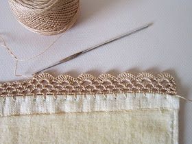 a close up of a piece of cloth with yarn and scissors on the table next to it