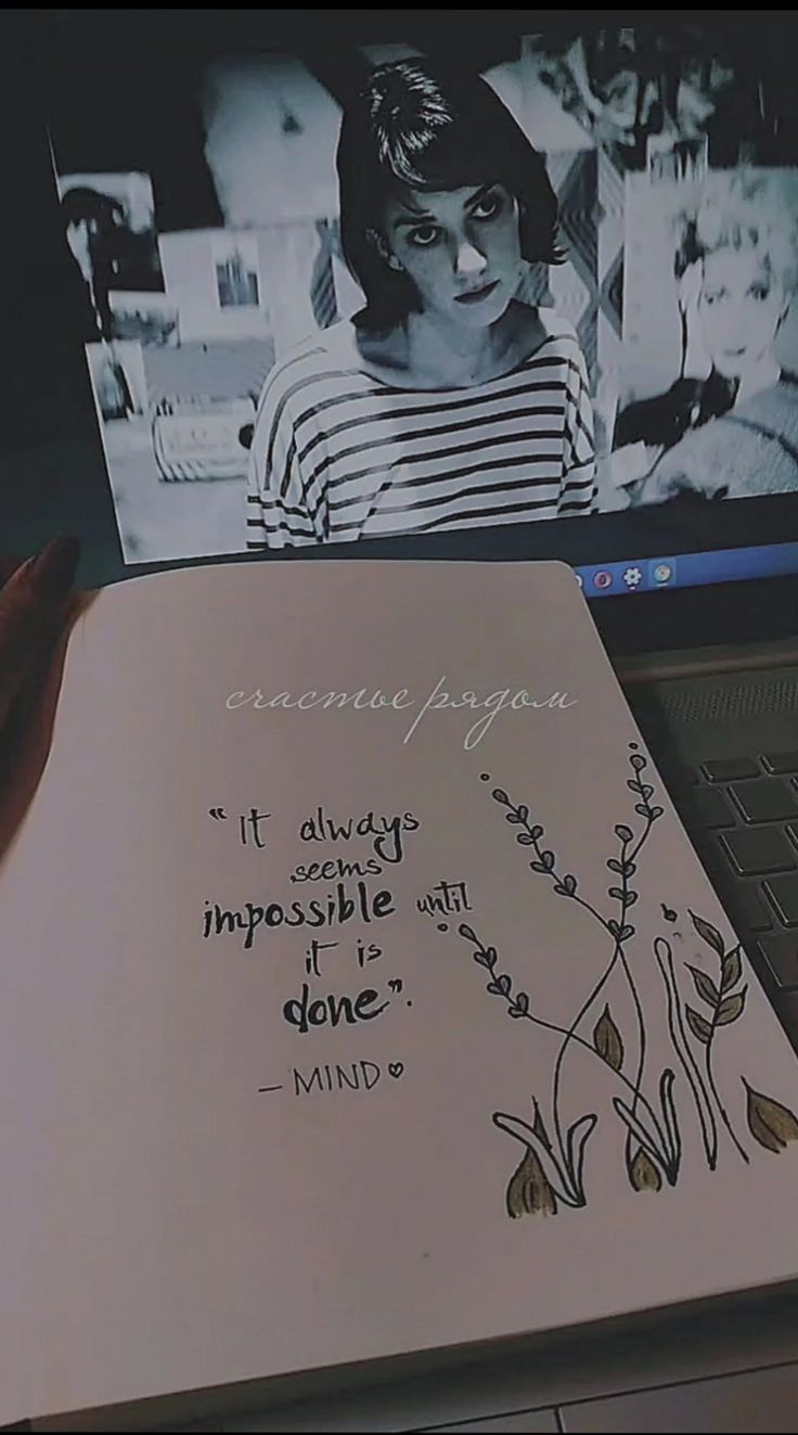 an open notebook sitting on top of a laptop computer next to a handwritten quote