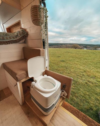 the interior of a camper with stairs leading up to it and a toilet in the foreground