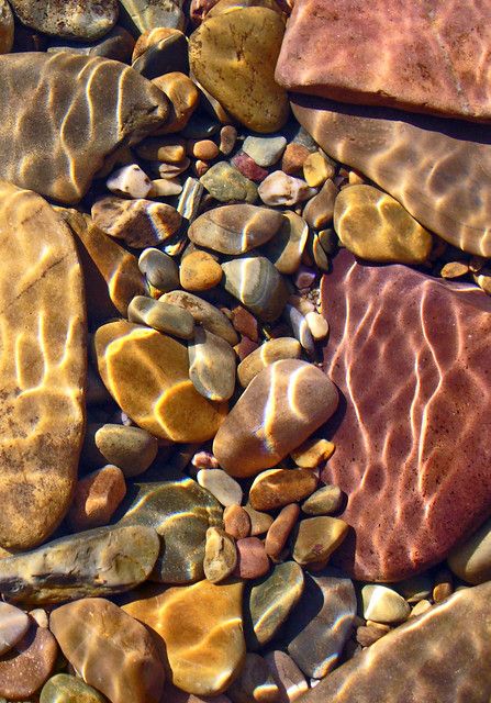 some rocks and water are on the ground by each other, as if they were floating in or out of the water